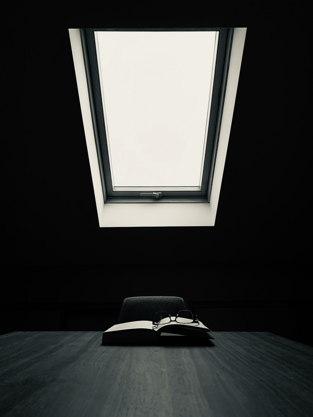 Reading glasses on an open book on a desk.