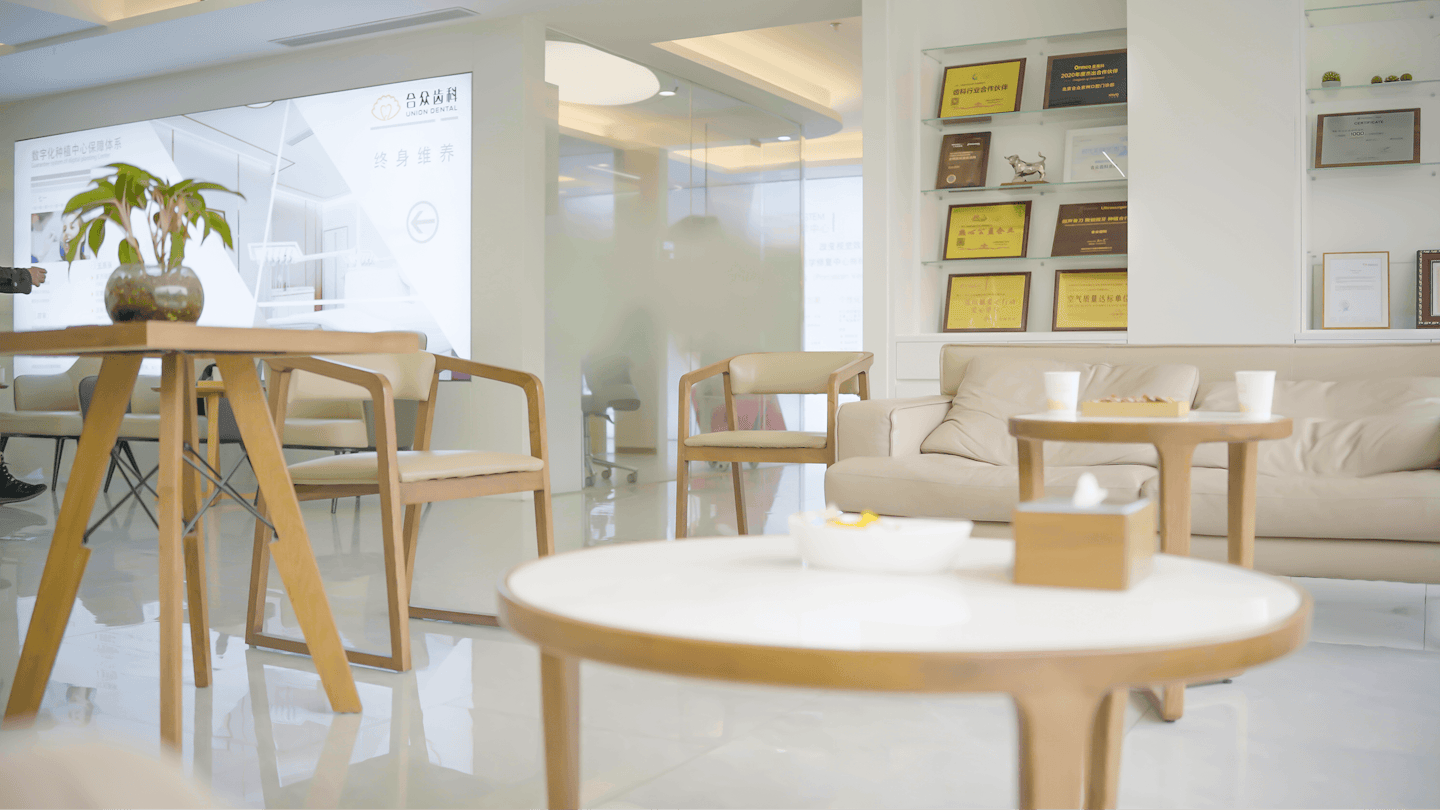 Modern professional waiting room with chairs and a beige sofa.